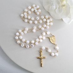 This Personalized Rosary, is ideal as a Baptism gift for a little girl or baby boy or as a gift for a special occasion. It is expertly handcrafted in a traditional style with a contemporary twist utilizing genuine Mother of pearl stone and gold-plated brass wire, which not only gives a touch of nature but also tenderness. The letter beads on the Rosary are also handmade from genuine mother of pearl, and the length is perfect to worn as a dainty Rosary necklace for women. *MATCHING ROSARY BRACELE Pearl White Rosary With 8mm Beads As Gift, Elegant White Rosary For First Communion, Round Polished Bead Rosary As Gift, Polished Round Beads Rosary As Gift, Pearl White Spiritual Rosary As Gift, Spiritual Pearl White Rosary Gift, Adjustable Round Rosary As Gift, Spiritual Pearl White Rosary As Gift, Beaded Cross Jewelry For First Communion