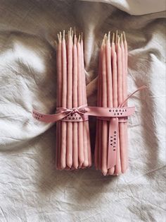 several pink candles tied together on a bed