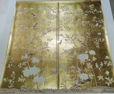 a gold screen with birds and flowers on it