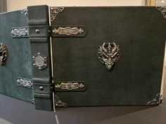 a green book with intricate designs on the front and back cover is sitting on a table