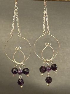 Artisan designed and handcrafted one of a kind  Amethyst gemstone hoop dangling earrings. Sterling silver components one large and one small connected. The amethyst is dangling from the bottom of the components. Sterling silver chain connects the components to the Sterling silver lever back earring. These earrings is presenting with one of the most popular gemstones, Amethyst. They are a deep rich purple faceted beads. Sterling silver component hoops. The amethyst dangling beads hanging from the Nickel-free Purple Dangle Chandelier Earrings, Sterling Silver Chandelier Earrings With Lever Back As Gift, Handmade Purple Sterling Silver Earrings, Silver Amethyst Wire Wrapped Earrings, Sterling Silver Teardrop Chandelier Earrings With Gemstones, Handmade Purple Sterling Silver Chandelier Earrings, Handmade Sterling Silver Teardrop Chandelier Earrings, Handmade Teardrop Sterling Silver Chandelier Earrings, Sterling Silver Gemstone Chandelier Earrings For Gift