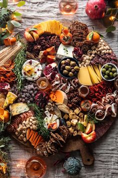 an assortment of cheeses, meats and vegetables on a platter