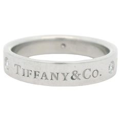 Tiffany & Co. Classic Band Ring, platinum featuring 3 round brilliant diamonds. The band style showcases "Tiffany & Co" engraving on the outside. The inside of the band is engraved "Tiffany Co PT950" Alex & Co synonymous for fine quality and creativity has been located in the greater Boston area for over 40 years. Most of the jewelry in our high-end boutique are exclusive and original designs, expertly handcrafted in our on-site studio. Every piece we create exhibits the finest setting skills and hand finishing. Our design capabilities are boundless as we bring together finest precious metals and gemstones of your choosing to make your dream a reality. Our luxurious, bespoke pieces in the conventional sense can be defined by creativity, craftsmanship and design. Our skill and the investmen Tiffany Setting, Tiffany Diamond, Platinum Wedding Band, American Modern, Platinum Engagement Rings, Modern Ring, Tiffany And Co, Diamond Rings Bands, Brilliant Diamond