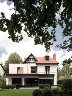 a large white house sitting on top of a lush green field