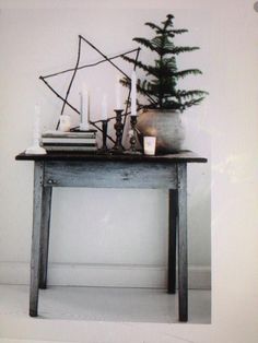 a wooden table topped with candles next to a potted plant