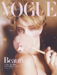 a magazine cover with a woman holding a lollipop in front of her face