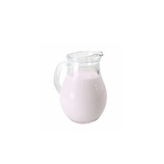 a glass pitcher filled with milk on top of a white table