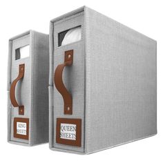 two grey boxes with brown handles and labels on them