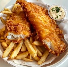 fried fish and french fries on a plate with dipping sauce