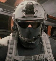 a man wearing a helmet and goggles in a sci - fi setting with other people behind him