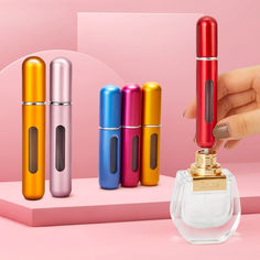 a person is holding an electronic device in front of four different colored lighters on a pink surface