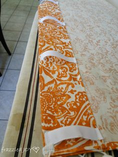 an orange and white table runner on top of a tile floor