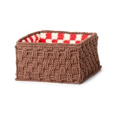 a crocheted basket with red and white squares on the bottom, sitting on a white surface