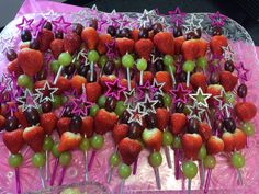 strawberries and grapes are arranged on skewers with star decorations in the middle