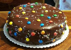 a chocolate cake with sprinkles and candy on the top is ready to be eaten