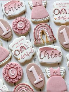 cookies decorated with pink and white icing are arranged in the shape of letters, numbers, and symbols