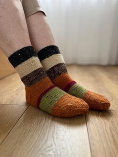 Hand-knitted autumn-colored socks are cozy, warm, and perfect for cooler weather. These socks feature rich hues like deep oranges, browns, and golden yellows, reminiscent of falling leaves. The intricate knit patterns add texture and charm, making them both stylish and functional. Perfect for wearing at home or with boots, these socks are a blend of comfort and seasonal beauty, celebrating the warm, earthy tones of fall. Chunky Knit Socks For Fall, Warm Brown Socks For Fall, Comfortable Knitted Socks For Fall, Casual Orange Socks For Fall, Comfortable Brown Socks For Fall, Handmade Casual Socks For Fall, Casual Brown Socks For Fall, Brown Knitted Socks For Fall, Cozy Knitted Socks For Fall