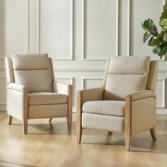 two chairs sitting next to each other on top of a hard wood floor in front of a white wall