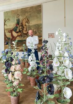 a man standing in front of a bunch of flowers