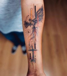 a person with a cross and an eagle tattoo on their arm is standing in front of a wooden floor