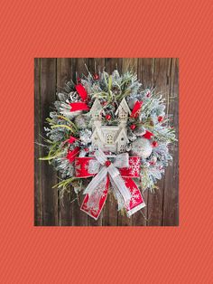 a red and white christmas wreath hanging on a wooden wall