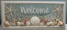 a welcome sign with seashells and starfish