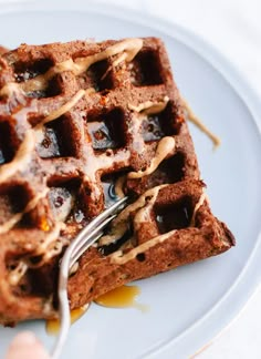 a waffle with syrup on it being eaten by a fork