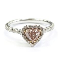 a heart shaped pink diamond ring with white diamonds on the sides and yellow gold accents