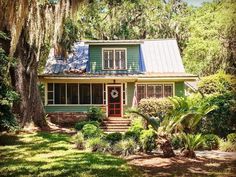 a green house surrounded by trees and grass