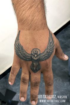 a man's hand with an owl tattoo on it