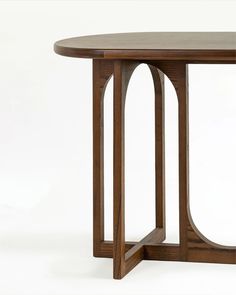 a wooden table with an oval shaped top and curved legs, against a white background