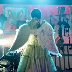 a woman dressed in an angel costume on stage