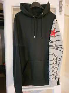 a black hoodie with red star on it hanging from a hook in a closet