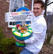 a man holding up a fake toothbrush in front of a building with a sign on it