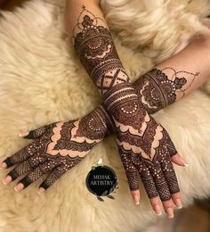 two hands with henna tattoos on them