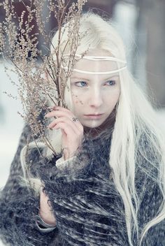 a woman with long white hair holding a plant