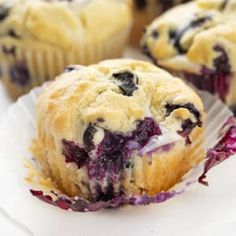 blueberry muffins sitting on top of white paper