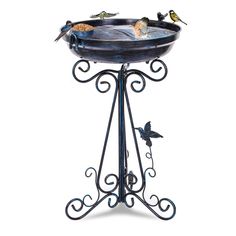 a bird bath with three birds sitting on it