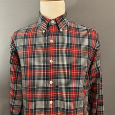 "You are viewing a classic Vintage Men's Button-Down Shirt by Polo/Ralph Lauren c1990s. This great looking shirt is made of a medium weight all cotton cloth in a fantastic plaid in red, blue, green, yellow and white. Details include button-down collar, embroidered blue Polo logo at left side of chest, 7 button placket (with pearlized white plastic buttons), long sleeves with single buttoned cuffs and one button up the hem, slightly rounded hem (longer in the back). Dates from likely the mid to l Classic Plaid Shirt With Placket, Classic Collared Flannel Shirt With Button Closure, Classic Plaid Shirt With Buttons, Polo Logo, White Details, Button Down, Un Logo, Men's Button Down Shirt, Mens Plaid