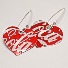 two red heart shaped earrings with the word sale written on them, sitting next to each other