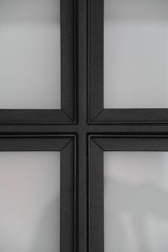 four square glass panels on the side of a black door