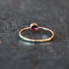 A gorgeous, rose-hued Rhodolite Garnet gemstone is handset entirely in 14k yellow gold. The bezel that holds the garnet stone is integrated right into the band, which I hammer for a sparkling, faceted finish. Rhodolite garnet has a much more raspberry tone than traditional garnet, and it is absolutely stunning paired with yellow gold. The gold I use is recycled and refined in the U.S. by an award-winning facility. This ring is made to order for you in your requested ring size. The garnet gemston Fine Jewelry Garnet Ruby Ring With Bezel Setting, 14k Gold Ruby Ring With Bezel Setting, Tourmaline Birthstone Ring With Bezel Setting, 14k Rose Gold Ruby Birthstone Ring, Rose Gold 14k Ruby Birthstone Ring, Pink Gold 14k Ruby Ring, Garnet Birthstone Ring In Yellow Gold, Rose Gold Bezel Set Ruby Ring In 14k Gold, Dainty Yellow Gold Ruby Ring With Bezel Setting