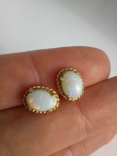 Opals are a very popular gem stone and looking at these earrings it's clear to see why! Each of these opals have a wide range of colours that glow as they hit the light, a bit like iridescent confetti - magical little stones! The opals are oval shaped cabochons set in 9ct yellow gold. Perfect condition Fully hallmarked on the earring posts for 9ct gold The front of each earring measures 1cm x 0.7cm across. 9ct Gold Earrings, Earrings Studs, Earring Posts, Opal Earrings, Gem Stone, Gold Earrings Studs, Opal Rings, Vintage Colors, Jewelry Earrings Studs