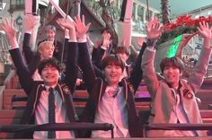 group of young boys in school uniforms waving