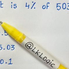 a yellow pen sitting on top of a piece of paper