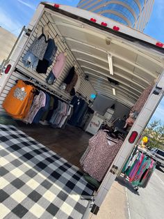 the back of a truck with clothing on display