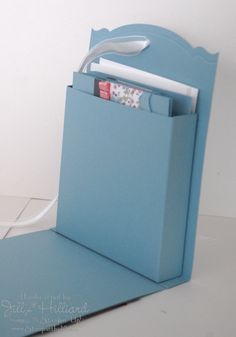 a blue folder holder with an envelope inside