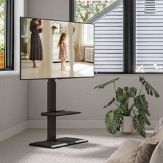 a flat screen tv sitting on top of a stand in a living room next to a window