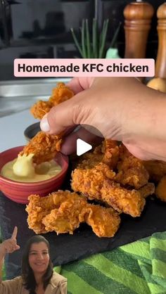 a woman is eating fried chicken with ranch dressing in front of her and the video below shows how to make homemade kfc chicken