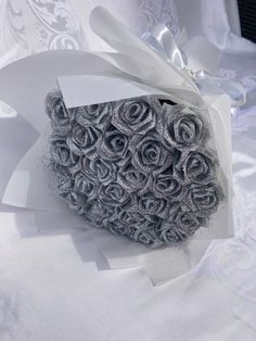 a bouquet of roses is wrapped in white paper